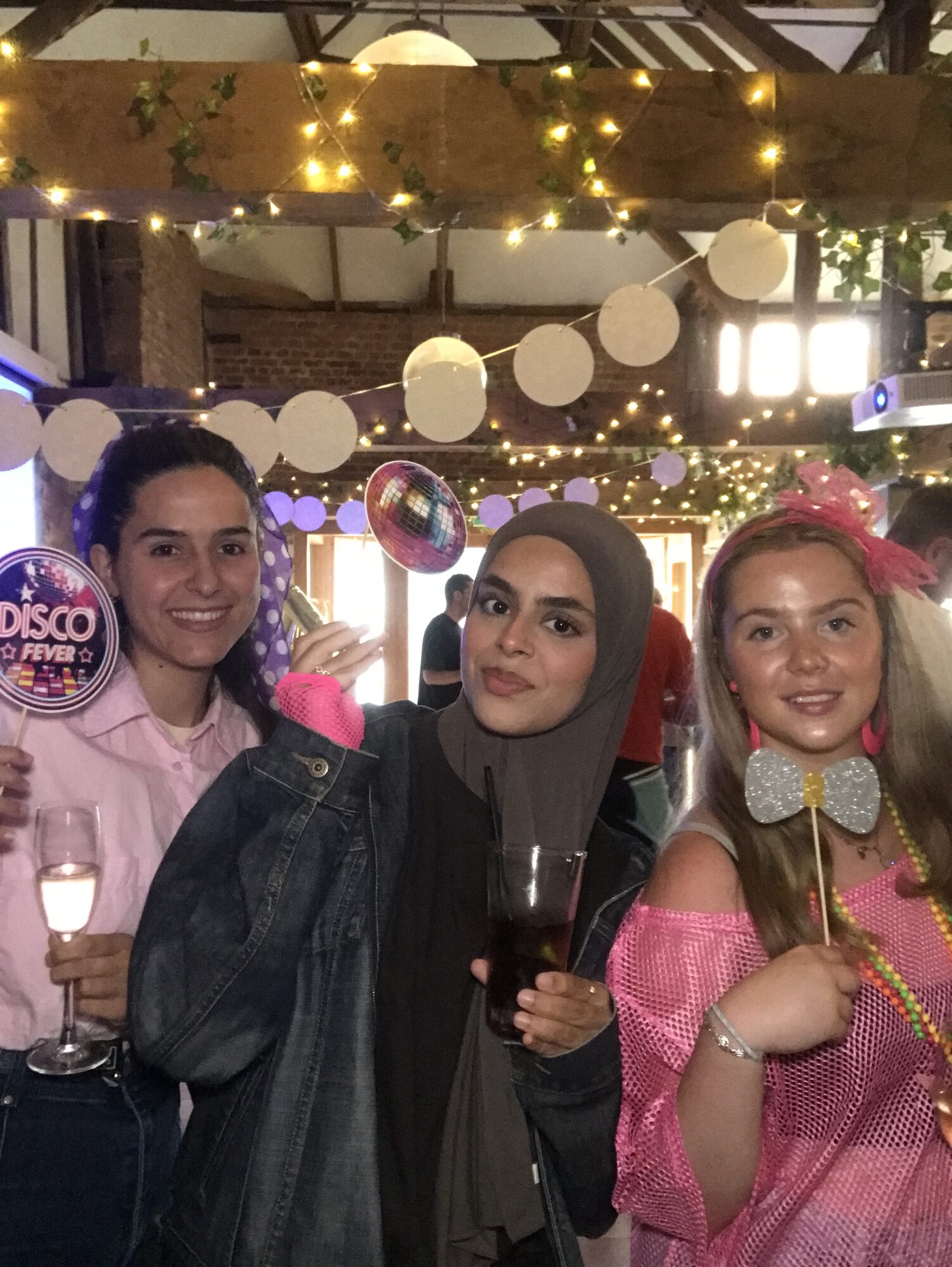 UK team members in the photobooth holding a disco fever sign