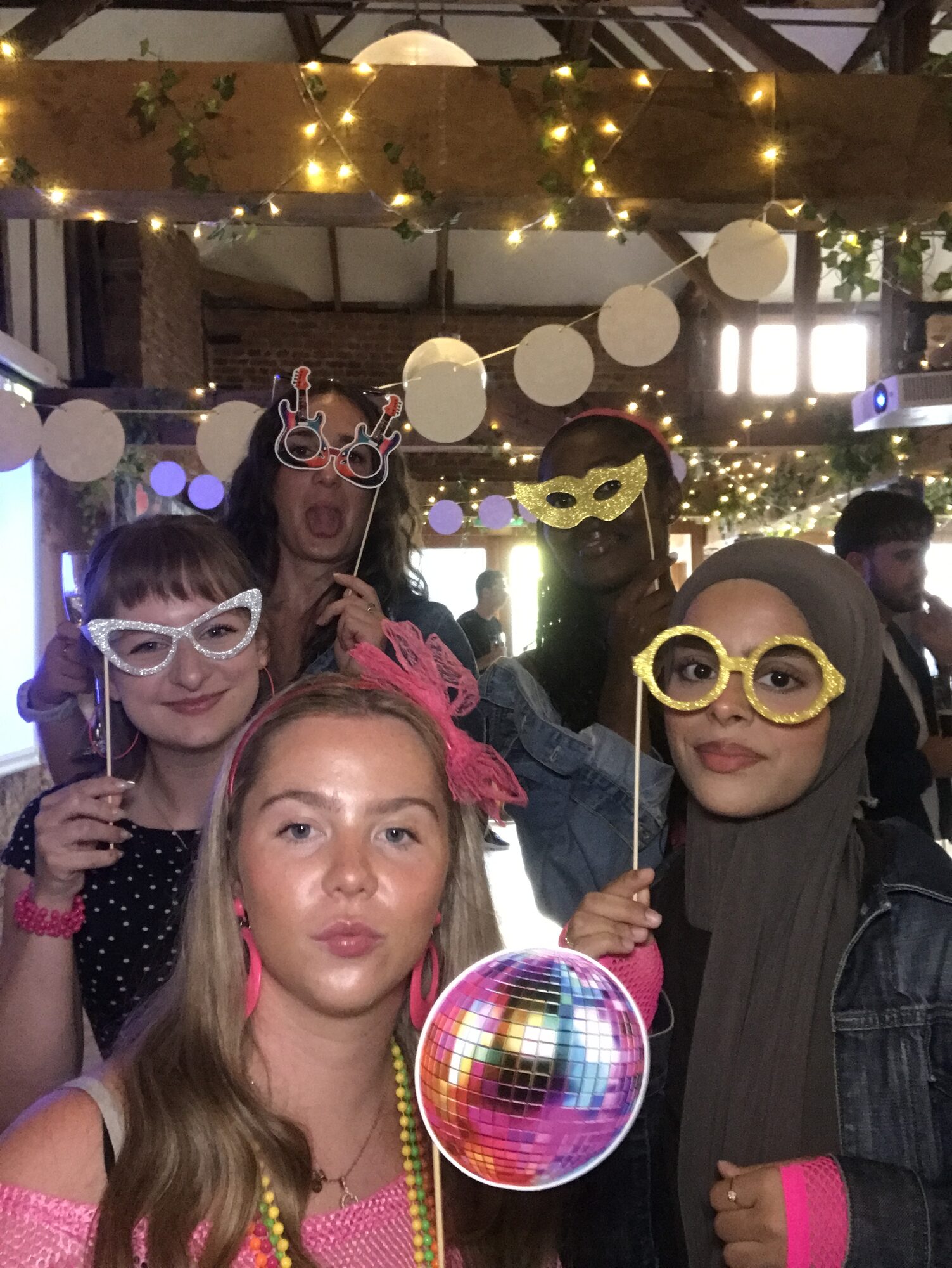 UK team member in the photobooth wearing guitar-shaped glasses