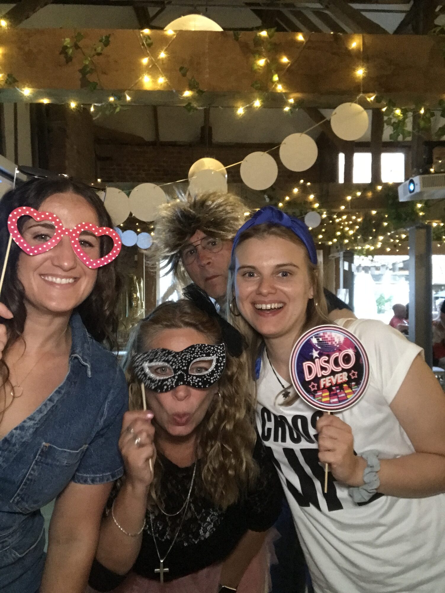 Four UK team members in the photobooth wearing heart-shaped glasses
