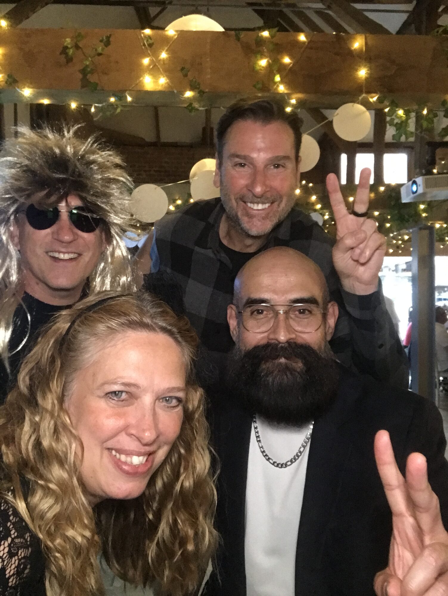 UK team in party wigs giving peace signs at the 40th anniversary celebration