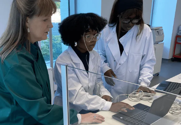 Dr. Ann Rajnicek instructs two students using a laptop and Lt to measure electroencephalography (EEG) signals.