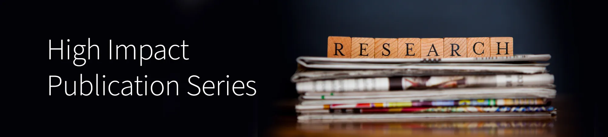 a stack of newspapers with scrabble tiles spelling out 'research' on top