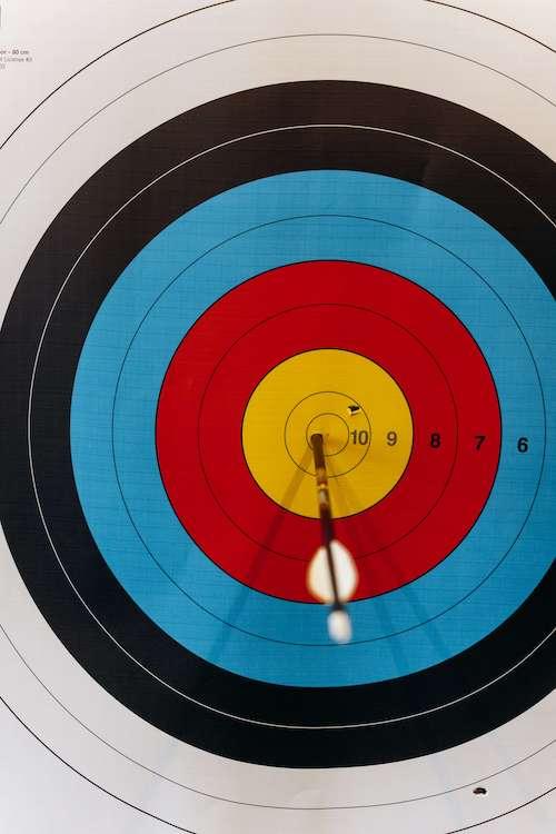 An image of an arrow in the middle of an archery target.