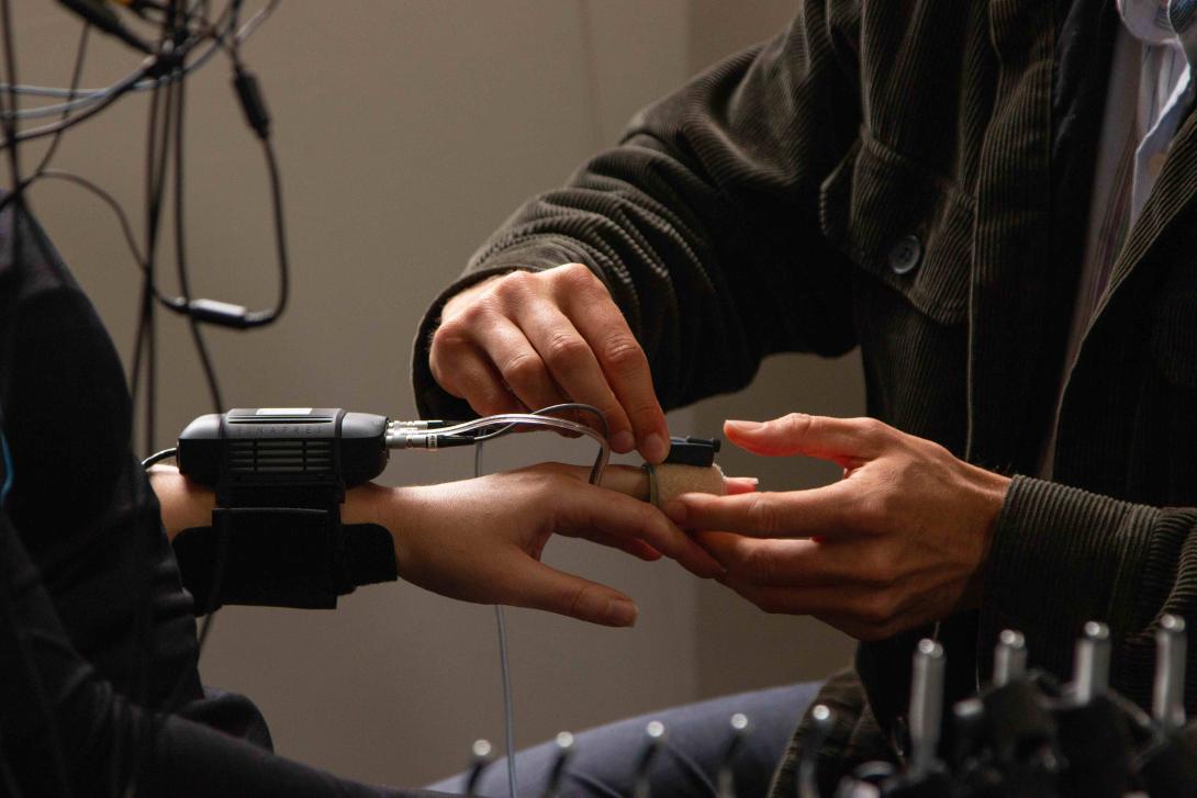 A person fitting a NIBP monitor on a second person's hand
